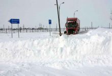 Camioane încărcate cu mărfuri blocate cu zăpadă într-o parcare